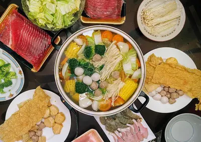a table with a pot of soup and plates of food at Teluk Batik 17ParadiseHome Private Pool Karaoke Snooker BBQ 15pax in Lumut