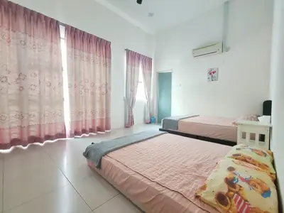 a bedroom with two beds and pink curtains at Teluk Batik 17ParadiseHome Private Pool Karaoke Snooker BBQ 15pax in Lumut
