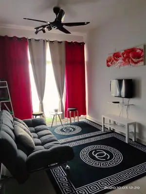 a living room with a couch and red curtains at HOMESTAY NazIPOH Meru in Ipoh