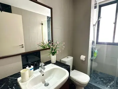 a bathroom with a sink and a toilet and a mirror at Landmark Lovely Coast View King Suite#500mbpsWifi#Netflix in Tanjong Tokong