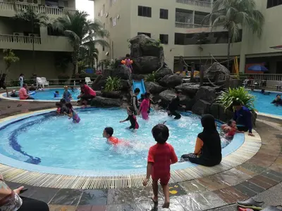 a group of children playing in a swimming pool at Pangkor Coral Bay Homestay 315 in Pangkor