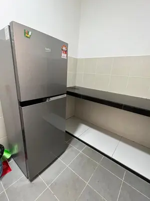 an empty kitchen with a refrigerator in a room at Cameron Emerald Avenue @ Brinchang in Cameron Highlands