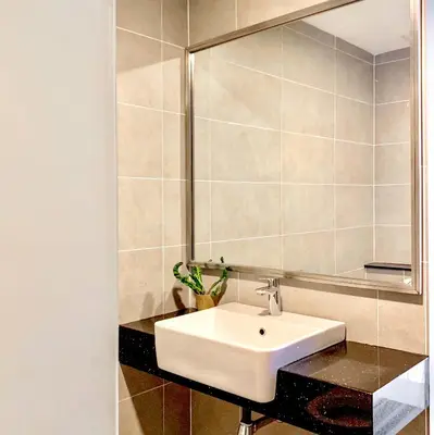 a bathroom with a sink and a mirror at Georgetown Tropicana 218 Apartment in George Town