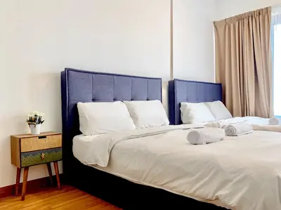 two beds with blue headboards in a bedroom at Georgetown Tropicana 218 Apartment in George Town
