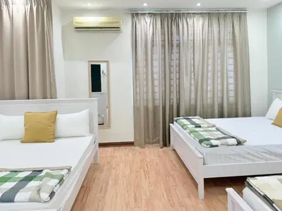 a bedroom with two beds and a window at Ocean 19 Shamrock Villa Beachfront Big Group 4 Bedroom 5 Bathroom with Pool in Tanjung Bungah