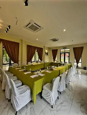 a large dining room with a long table and white chairs at Cinta Abadi Resort in Bidur