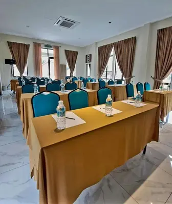 a conference room with tables and chairs with water bottles on them at Cinta Abadi Resort in Bidur
