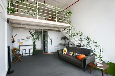 a living room with a couch and ivy on the wall at Private Forest Camp - Cinema, Hammock, Swing at CEO Penang in Bayan Lepas
