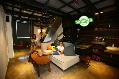 a man sitting on a couch in a room with a laptop at Private Getaway (Private Cinema, Swing & more!) at CEO Penang in Bayan Lepas