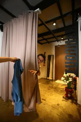 a woman standing behind a curtain in a room at Private Getaway (Private Cinema, Swing & more!) at CEO Penang in Bayan Lepas
