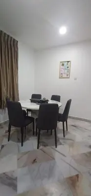 a table and chairs in a room with a white wall at Cozy Corner House #4 Bedroom #3 Bathroom in Ipoh