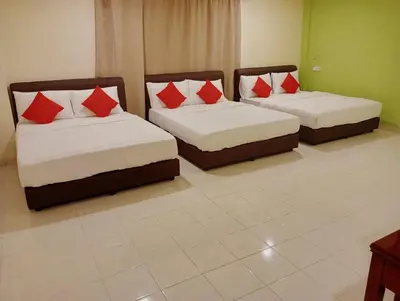 two beds with red pillows in a room at HOTEL SAHARA INN TANJUNG MALIM in Kampong Chabang