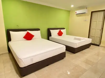 two beds in a room with green walls and red pillows at HOTEL SAHARA INN TANJUNG MALIM in Kampong Chabang