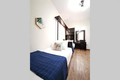 a hotel room with a bed with a blue blanket at EEs Whale House - Homestay 3 min walk to beach in Batu Ferringhi