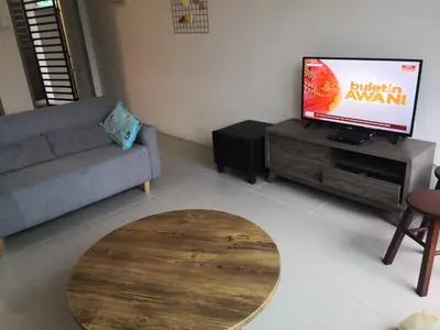 a living room with a couch and a flat screen tv at Lily Homestay Barrington Square Cameron Highlands. in Brinchang