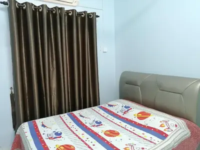 a bed with a blanket on it next to a curtain at YITOM Homestay\u6613\u901a\u6c11\u5bbf in Sungai Besar