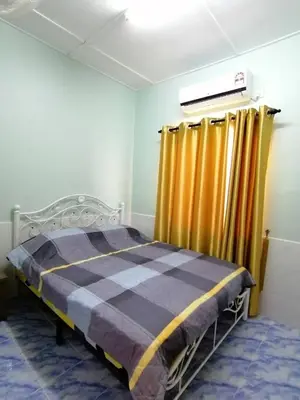 a bedroom with a bed and yellow curtains at Mui Gim Homestay \u5927\u6e2f \u7f8e\u666f\u6c11\u5bbf in Sungai Besar