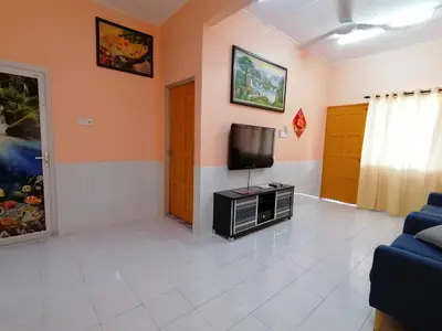 a living room with a tv and a couch at Mui Gim Homestay \u5927\u6e2f \u7f8e\u666f\u6c11\u5bbf in Sungai Besar