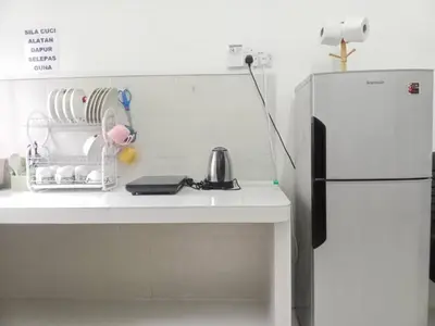 a kitchen with a white counter and a refrigerator at LILY VACATION HOME at CAMERON HIGHLANDS - 12 PAX,FREE WiFi w CARPORCH in Tanah Rata