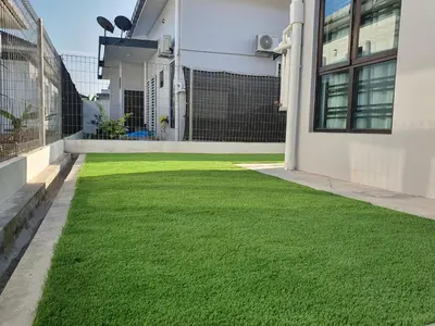 a yard of green grass on the side of a building at Homestay D'Bertam, Kepala Batas, Penang, Muslim Saja in Kepala Batas