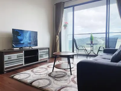 a living room with a tv and a couch and a table at Relax Bear Homestay in Tanah Rata