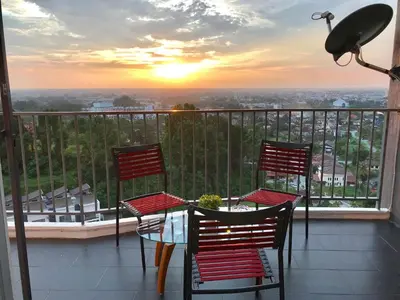 a table and chairs on a balcony with a sunset at Taiping Rain Town Homestay\u592a\u5e73\u96e8\u57ce\u540d\u5bbf two car park in Taiping