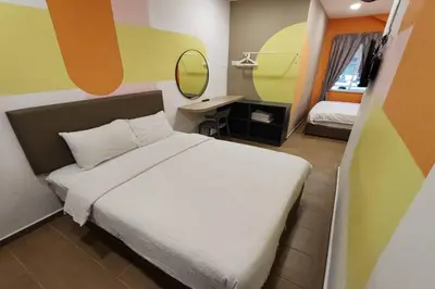 a bedroom with a bed and a desk with a mirror at Moon Hotel, Cameron Highlands in Brinchang