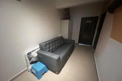 a living room with a black couch and a blue stool at Moon Hotel, Cameron Highlands in Brinchang