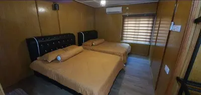 two beds in a small room with a window at Branda Kampung Sumpitan Lenggong TIADA SUNGAI in Kampong Ulu Jepai