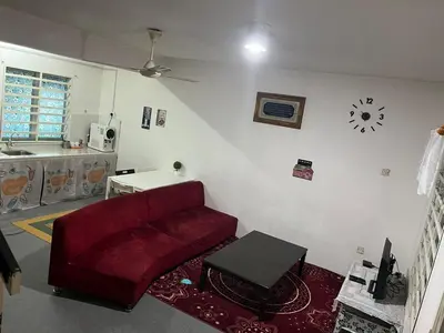 a living room with a red couch and a table at lost world of tambun homestay in Ipoh