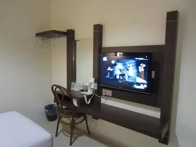 a tv on a wall in a hotel room at Radiant Hotel in Sitiawan