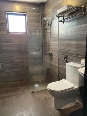 a bathroom with a toilet and a glass shower at See Foo Hotel in Bidur