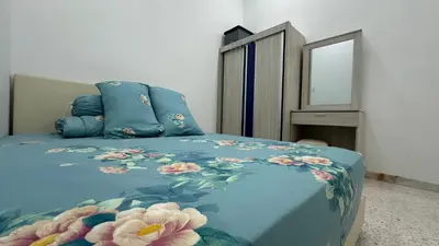a bedroom with a blue bed with flowers on it at Taman Bagan Single Storey Terrace House, 9mins to Sunway Carnival Mall, Seberang Jaya in Butterworth