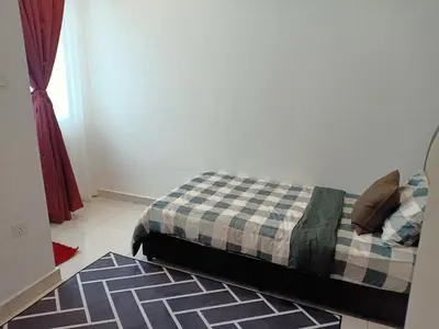 a bedroom with a bed with a checkered blanket at As Syifaa Homestay Mslim only in Ipoh