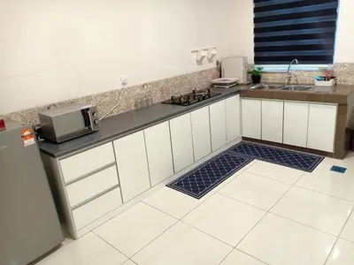 a kitchen with white cabinets and a counter with a microwave at As Syifaa Homestay Mslim only in Ipoh