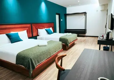 a hotel room with two beds and a screen at The Journey hotel in George Town