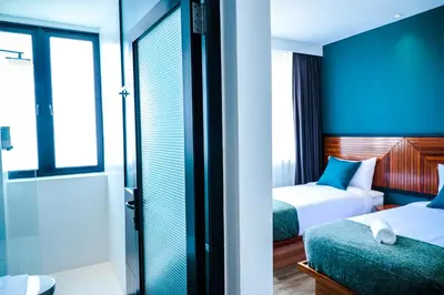 a hotel room with two beds and a shower at The Journey hotel in George Town
