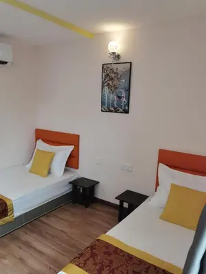 a bedroom with two beds and two tables at MORNINGS HOTEL in Sungai Petani