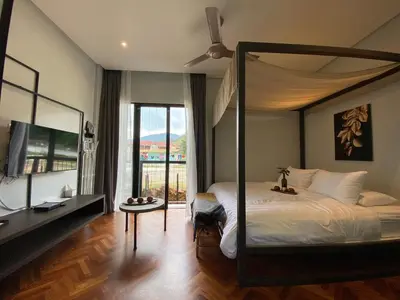 a bedroom with a canopy bed with a television and a window at Ten Mentigi in Tanah Rata