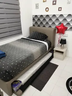 a bedroom with a bed with a black comforter at MN HOMES in Ipoh