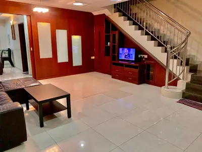 a living room with a staircase and a television at Awani Homestay Seberang Jaya in Permatang Janggus