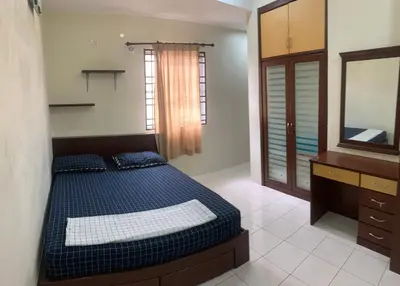 a bedroom with a bed and a dresser and a mirror at Awani Homestay Seberang Jaya in Permatang Janggus