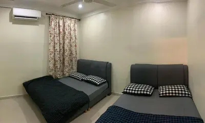 a bedroom with a bed and a window with two pillows at Awani Homestay Seberang Jaya in Permatang Janggus