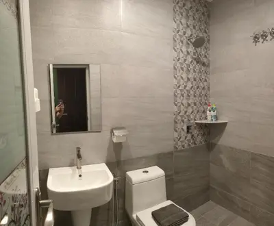 a bathroom with a sink and a toilet and a mirror at Just Austin Guesthouse in Ipoh