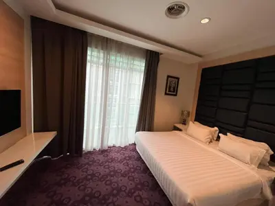 a hotel room with a bed and a large window at Jindagu Hotel Ipoh in Ipoh