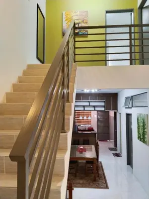 an open staircase in a house with a kitchen at Kayu Cengal Homestay in Seri Iskandar