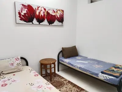 a room with a bed and a table and a chair at Kayu Cengal Homestay in Seri Iskandar