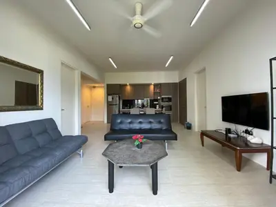 a living room with a couch and a table at By The Sea Cozy Beachfront Home, Batu Ferringhi in Batu Ferringhi