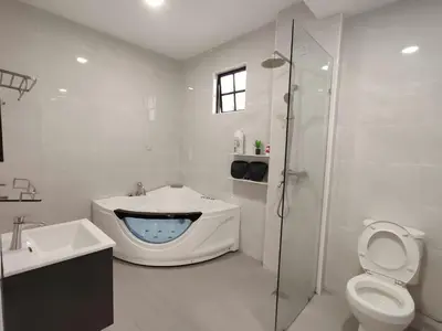 a bathroom with a tub and a toilet and a sink at SS Ipoh Comfort Homestay - Taman Bertuah in Ipoh