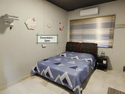 a bedroom with a bed with a blue comforter at G East Ipoh Garden Guesthouse in Ipoh